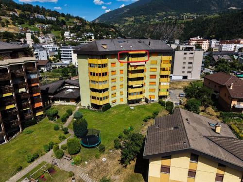 an apartment building with a red circle on the top of it at Apartment Above the Rooftops - Mountain Panorama in Naters