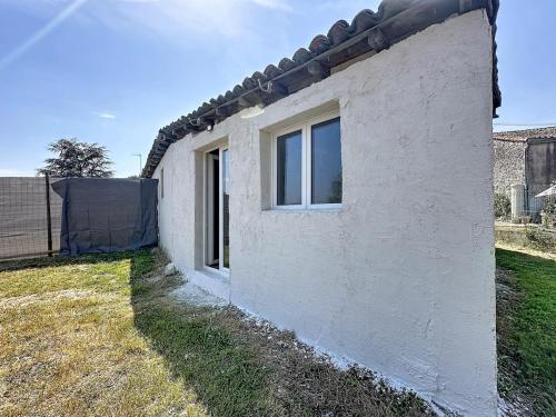 a side view of a white brick house at Maisonnette avec jardin privé in Secondigny
