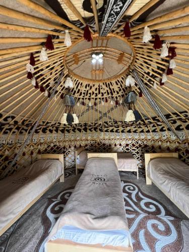 a large room with two beds in a yurt at Kel-Suu Manap in Kol-Suu