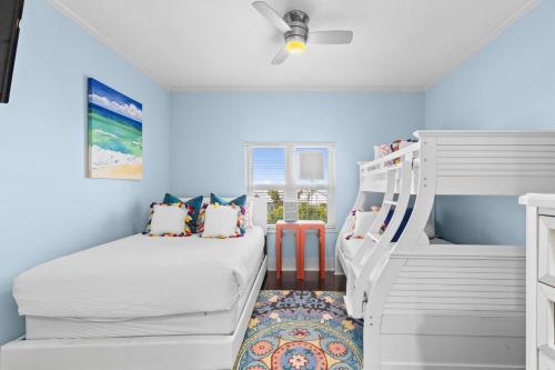 two beds in a room with blue walls at The Alexander in Rosemary Beach