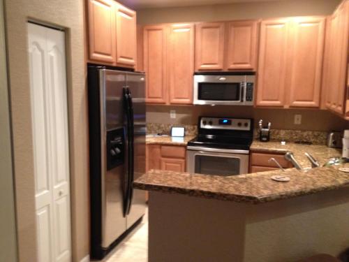 a kitchen with wooden cabinets and stainless steel appliances at Speedway Blvd Townhouse in Homestead