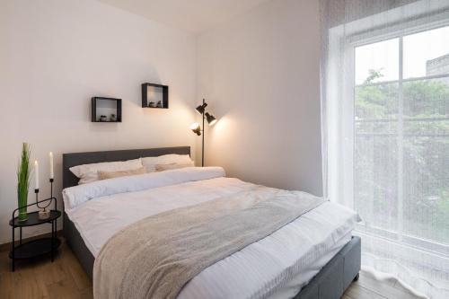 two beds in a bedroom with a large window at Apartamenty 9A Zgorzelec - Centrum in Zgorzelec