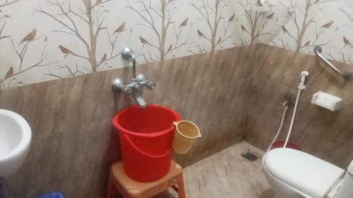 a bathroom with a toilet and a bucket at CHIDAMBARAM Bala Residency in Chidambaram