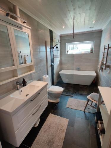 a bathroom with a tub and a sink and a toilet at Ulriksdal in Ulriksdal