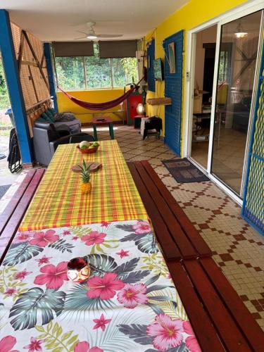 a bedroom with a table with a flower pattern on it at Chambre d'hôtes Jungle Hostel in Le Morne Rouge