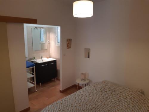 a bedroom with a bed and a sink and a mirror at RDJ Proche mer "L'Oustaou Cabriole" in Saint-Cyr-sur-Mer