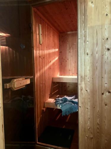 a wooden sauna with a blue towel in it at Zen appartement in Vries