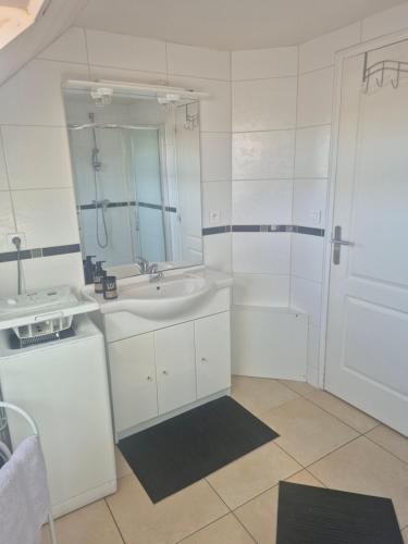 a white bathroom with a sink and a mirror at Studio Cosy à la campagne, à 30 min des plages in Missillac