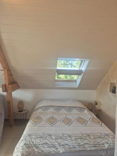 a bedroom with a bed and a window at Studio Cosy à la campagne, à 30 min des plages in Missillac