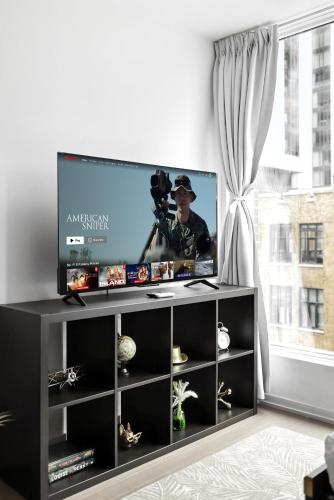 a black entertainment center with a flat screen tv at Entertainment District Gem Walk to CN Tower in Toronto