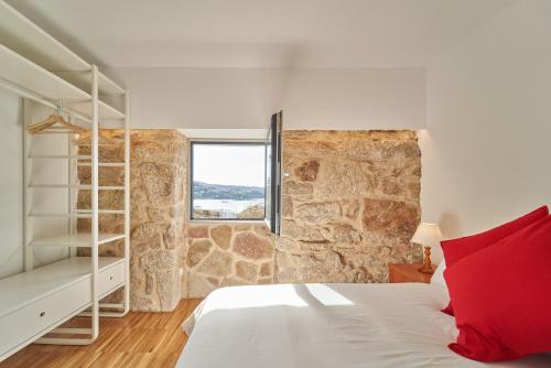 a bedroom with a bed and a stone wall at Views and Beds in Pontevedra