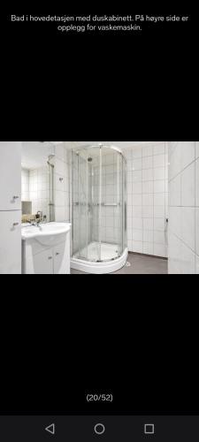 a white bathroom with a shower and a sink at Grefstadvigveien 12 in Grimstad