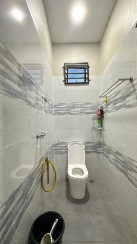 a bathroom with a toilet and a window at Baba Homestay in Macang