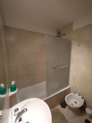 a bathroom with a sink and a toilet and a tub at WB1c in Puerto Madryn