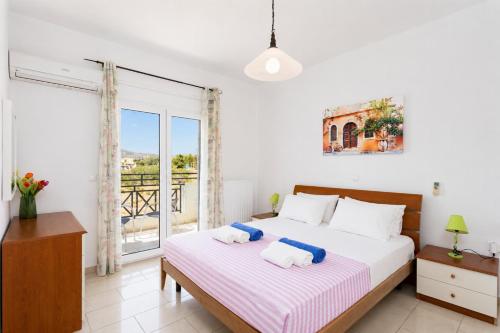 a bedroom with a bed and a balcony at Amphitrite Villa in Gennadi