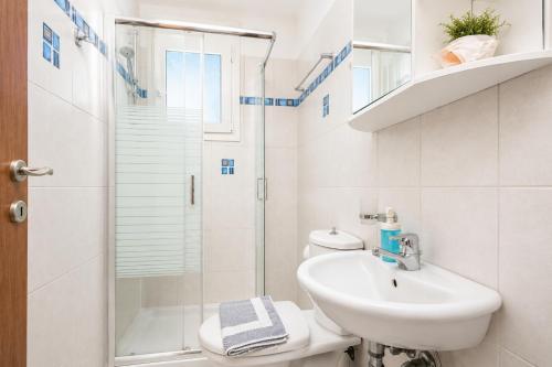 a white bathroom with a sink and a shower at Amphitrite Villa in Gennadi