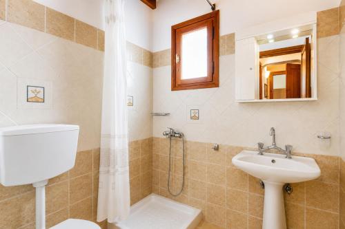 a bathroom with a sink and a toilet and a shower at Villa Ioanna in Skopelos Town