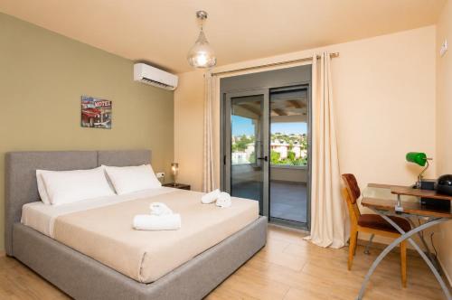 a bedroom with a bed and a desk and a computer at Villa Ammos in Afantou