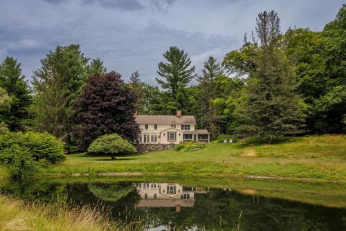 a house on a hill next to a lake at The Whistling Oak - Pristine Pond Tranquility in Craryville
