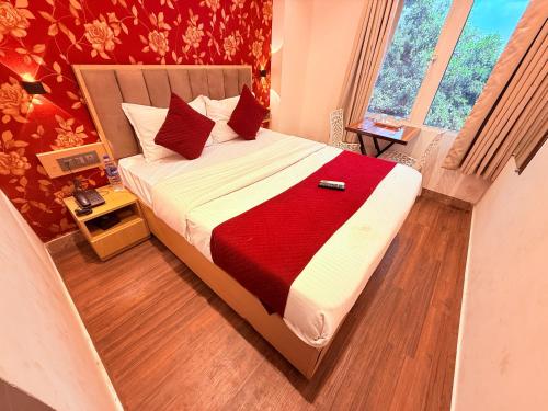 a bedroom with a large bed with a red blanket at Hotel Iris Inn - Near Lodha Palava, Dombivali in Dombivli