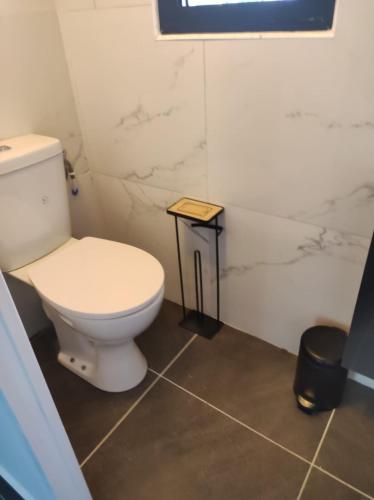 a bathroom with a white toilet and a stool at Villa Pauline in Les Abymes