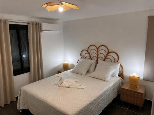 a bedroom with a bed with two shoes on it at Villa Pauline in Les Abymes