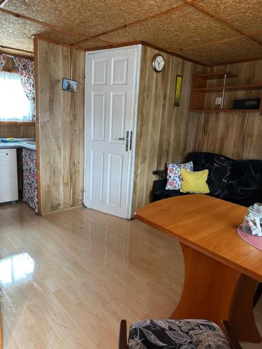 a living room with a white door and a table at Domki ALKANA - domek 3 in Nowęcin