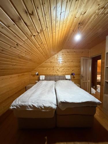 a large bed in a room with a wooden ceiling at GomisMta-Luxury Cottage with Panor in Gomi