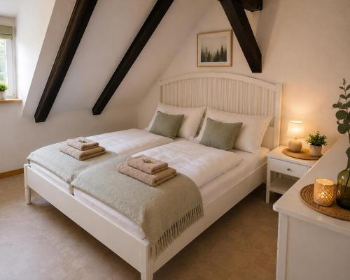a bedroom with a white bed with towels on it at Alte Faktorei Schierke in Schierke