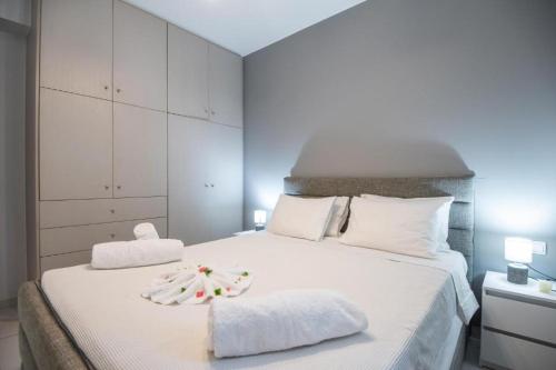 a bedroom with a white bed with two towels on it at Ermira in Agios Nikolaos