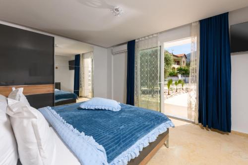 a bedroom with a bed and a large window at Oasis deluxe apartments in Skala Rachoniou