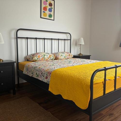 a bedroom with a bed with a yellow blanket and pillows at Bajta 163 in Topusko