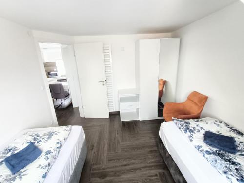 a bedroom with two beds and a chair at Haus,Weinberg22 in Rüsselsheim