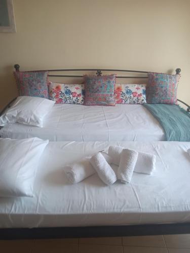 a white bed with two white pillows on it at Melinas Home in Chrysoupolis