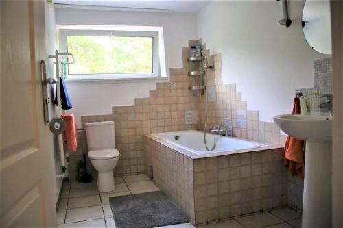 a bathroom with a tub and a toilet and a sink at TanieSpanie in Legionowo