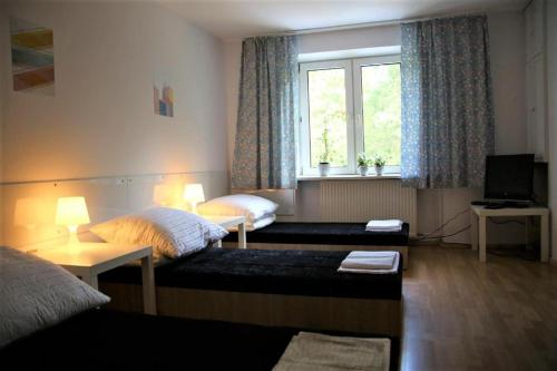 a hotel room with two beds and a window at TanieSpanie in Legionowo