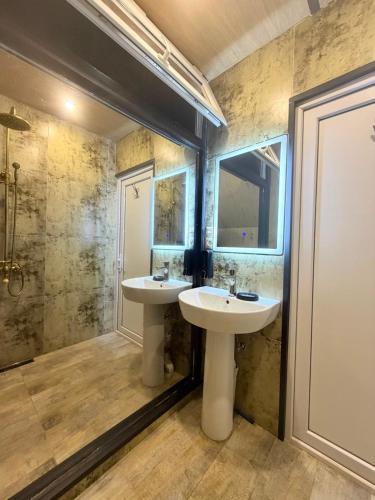 a bathroom with two sinks and a shower at Panorama Cottage in Erge