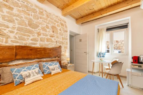 ein Schlafzimmer mit einem Bett und einer Steinwand in der Unterkunft Tra Cale e Rioni in Baunei