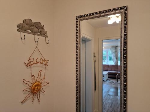 a mirror hanging on a wall with a welcome sign at Goting-Sonne in Borgsum