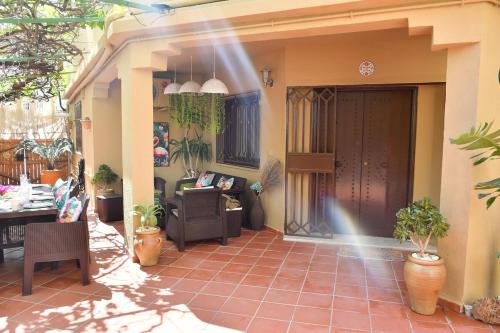 a patio with a porch with a couch and a table at Hacienda Oliva in Hammam Sousse