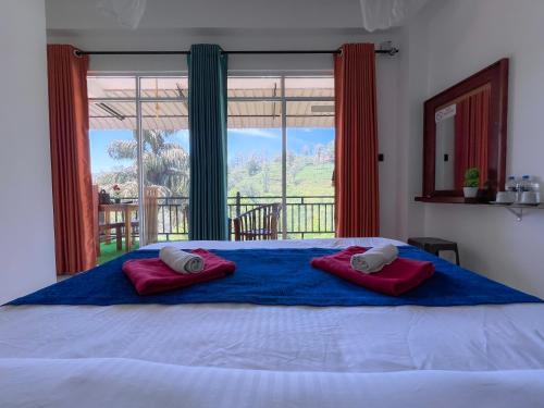 a bedroom with a bed with two red pillows on it at Tea Pick View Ella in Ella