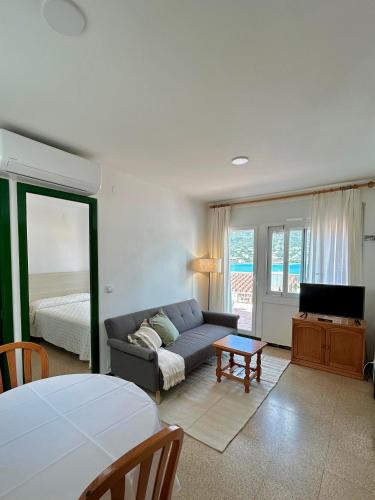 a living room with a couch and a bed at Apartaments Tramuntana in Port de la Selva