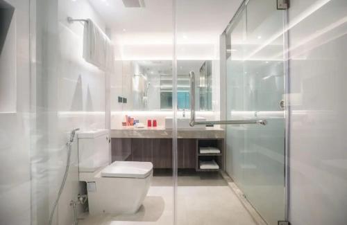 a bathroom with a toilet and a glass shower at The- Luxury Enclave Plaza Near IGI Airport Delhi in New Delhi