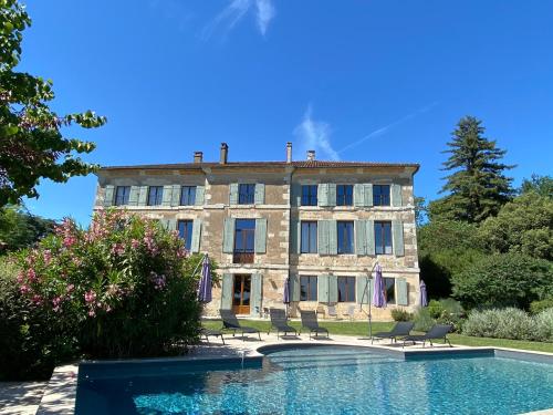 a large stone building with a pool in front of it at Domaine de Bernou in La Croix-Blanche