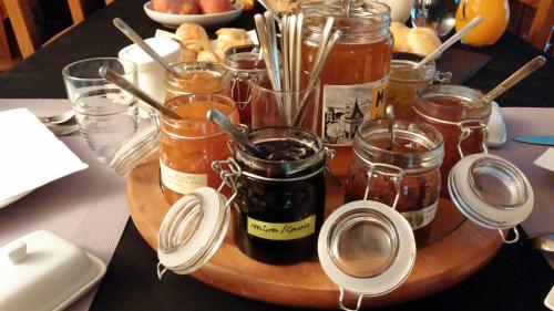 a wooden tray with jars of jam on a table at Moulin de Record in Ferrières