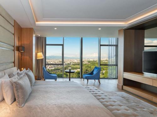 a bedroom with a large bed with a large window at Mövenpick Hotel & Thermal Spa Bursa in Bursa