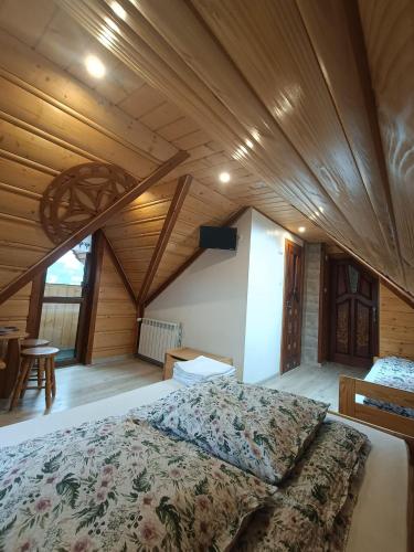 a large bed in a room with a wooden ceiling at Pokoje gościnne u Krupy in Murzasichle