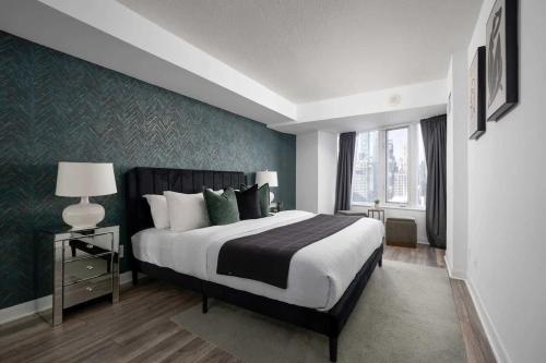 a bedroom with a large bed and a large window at Modern King Suite Steps to Eaton Centre in Toronto