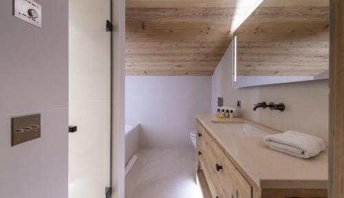 a bathroom with white walls and a wooden ceiling at Spacious Apartment in Tignes in Tignes
