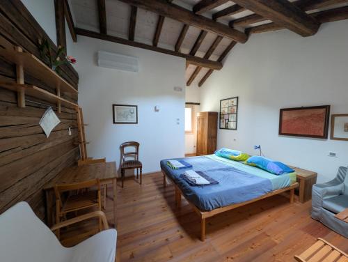 a bedroom with a bed in a room with wooden floors at Agriturismo Corte del Maso in Bassano del Grappa